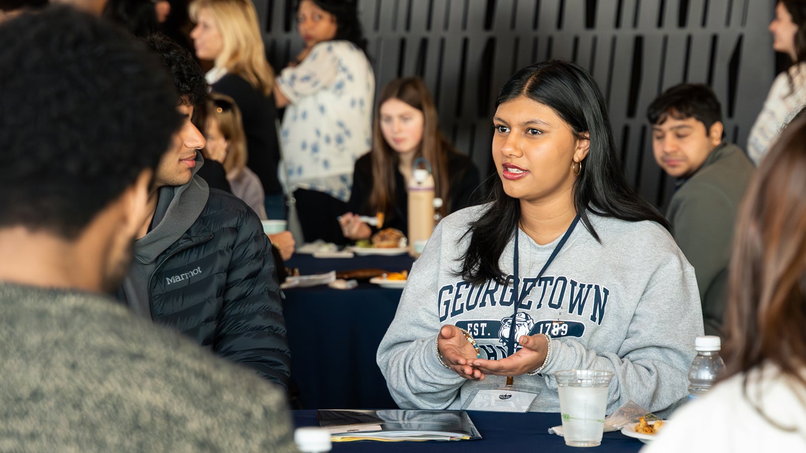 A student wearing a Georgetown sweatshirt speaks to prospective students during an admitted student weekend.