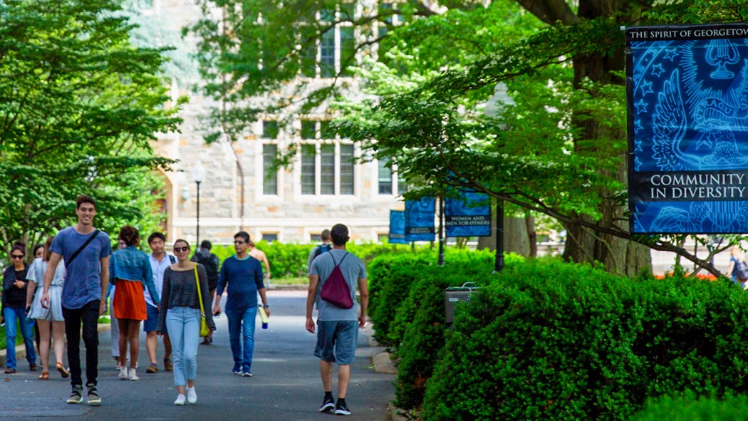 Students walk along a path in front of Copley Hall.