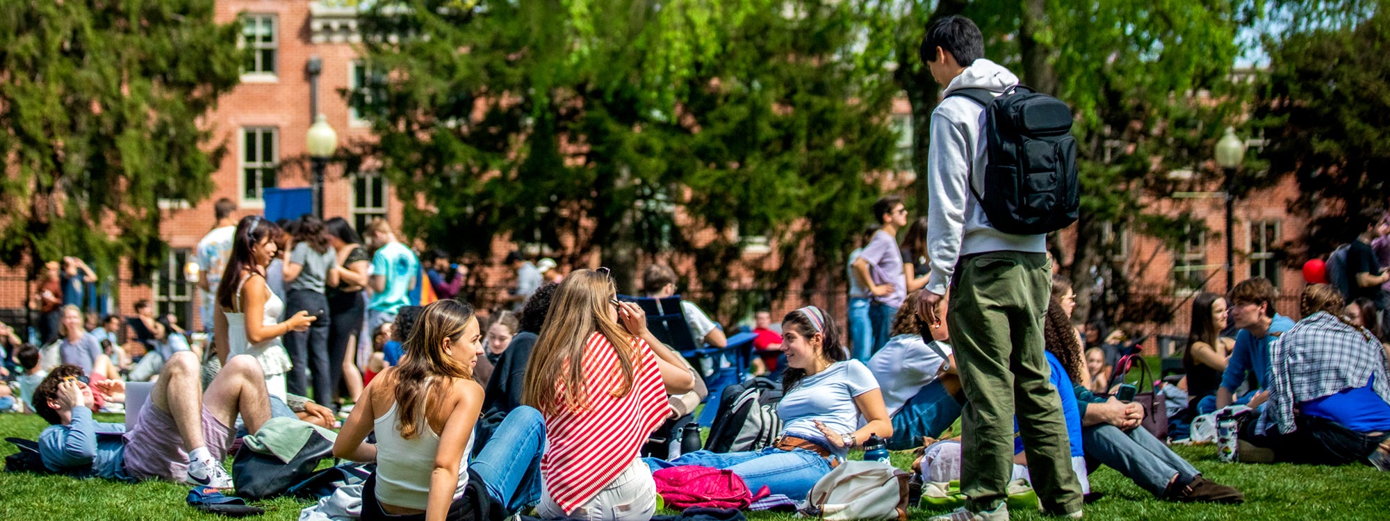 A group of students lounge on Healy Lawn. Some students are sitting, while others are lying down of standing.