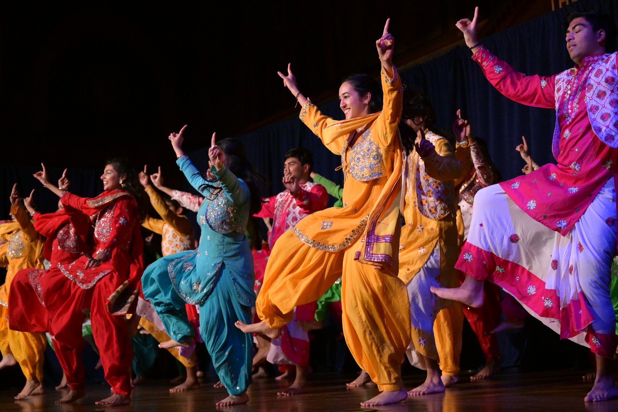Students dressed in colorful South Asian clothing dance during the Rangila Dance Show.