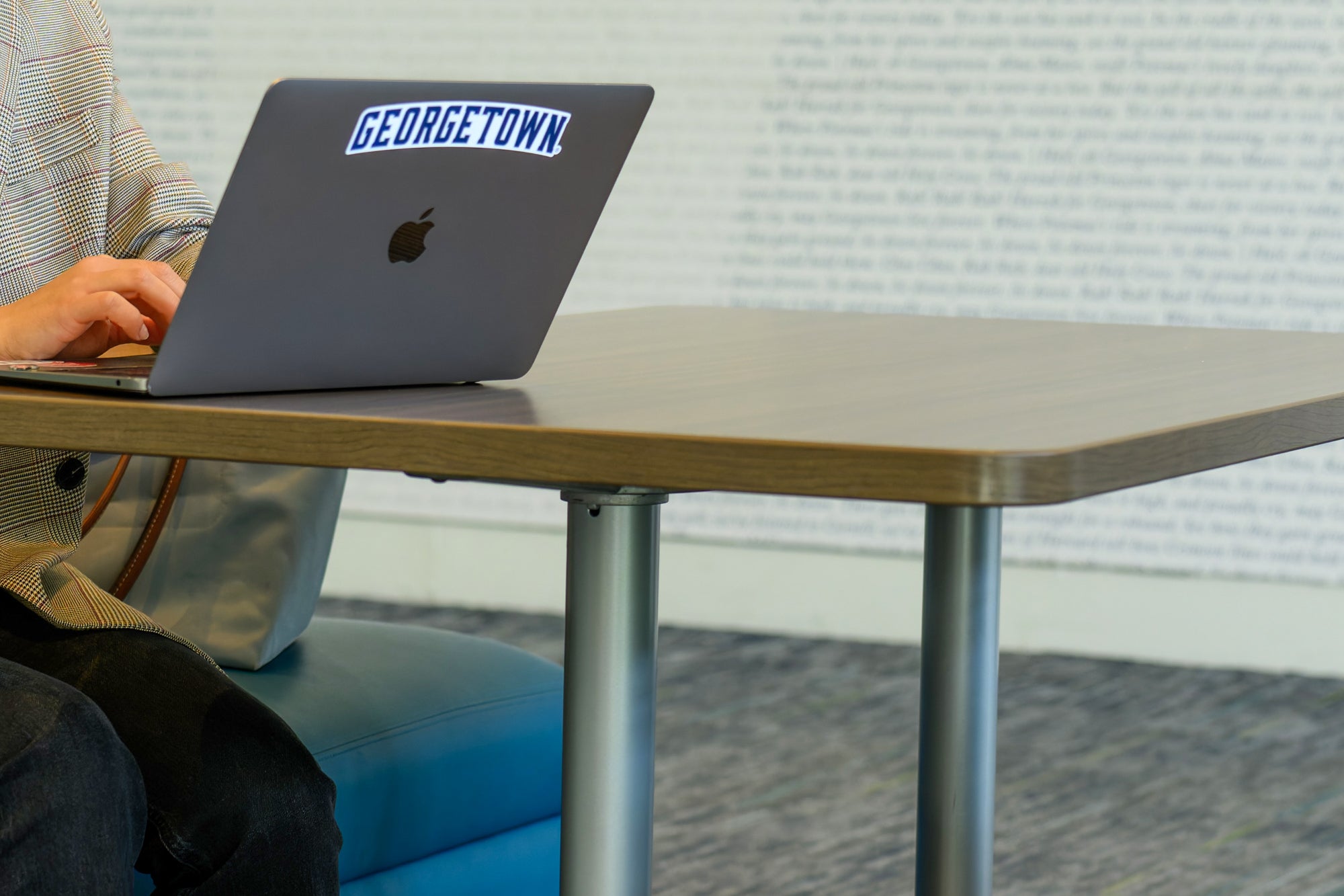 A laptop with a Georgetown sticker on it sits on a table.